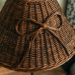 Close-up of a woven brown hat with a bow on a blurred background