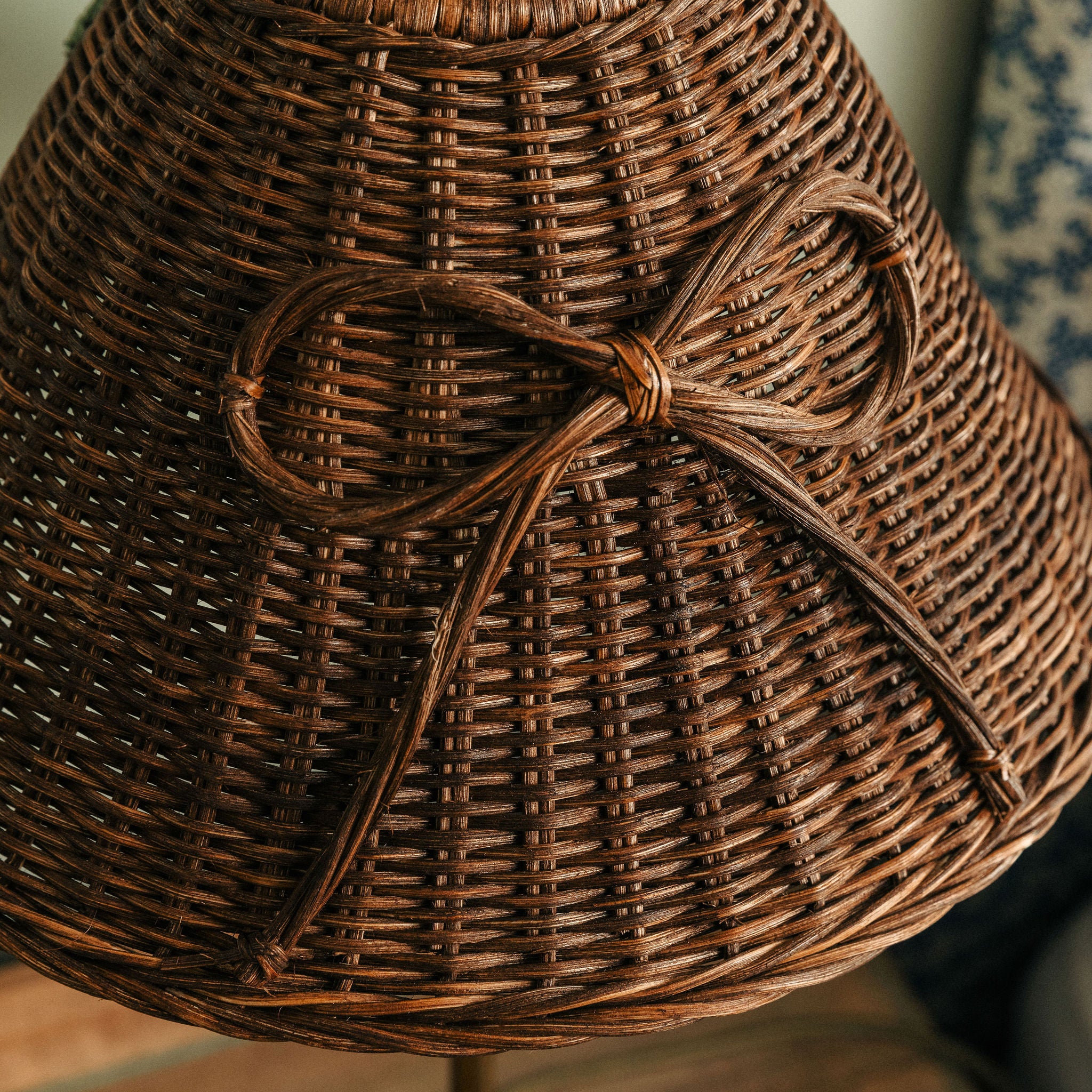 Close-up of a woven brown hat with a bow on a blurred background