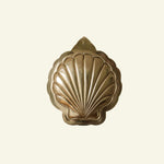 Decorative brass shell on a beige background