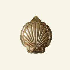 Decorative brass shell on a beige background