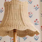 Wicker lampshade on a floral wallpaper background