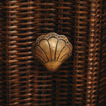 Decorative metal shell on a woven brown background