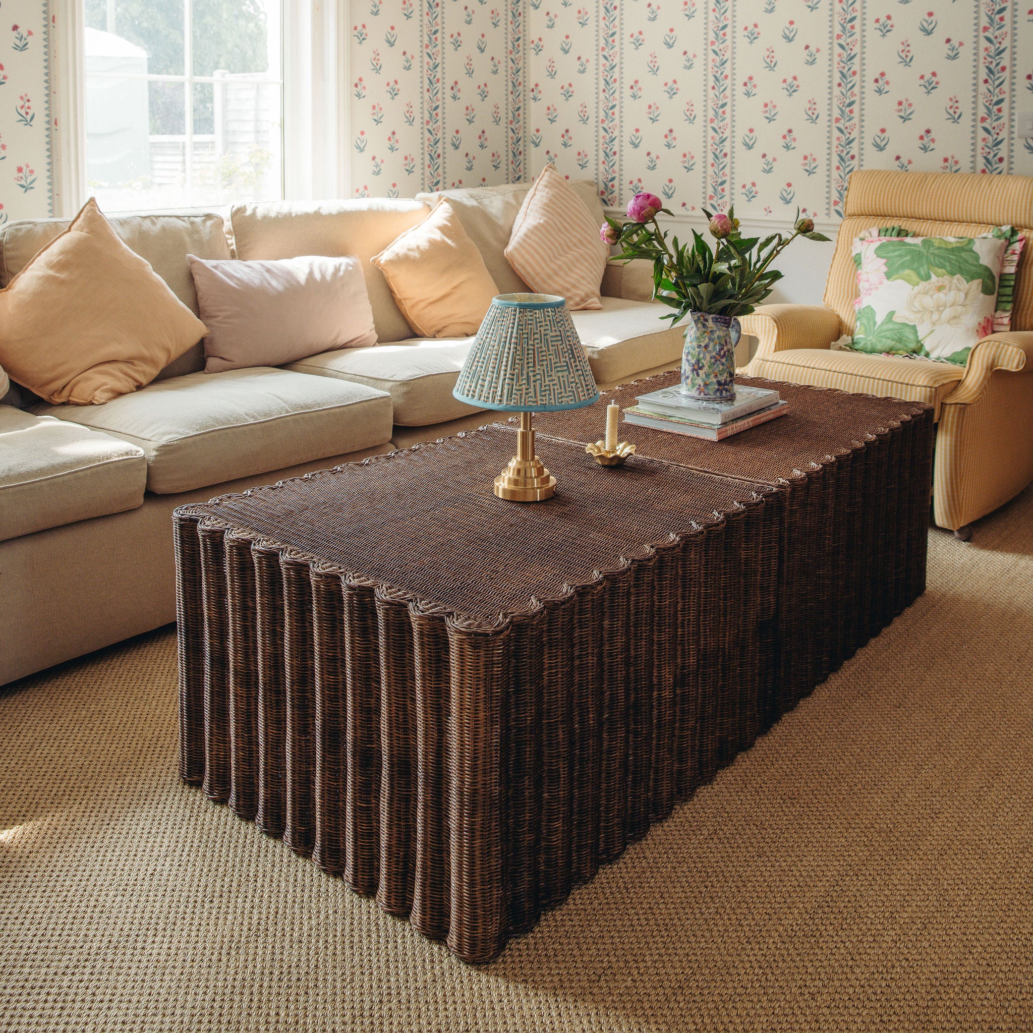 Living room with a Daisy wicker coffee table, beige sectional sofa, and armchair.