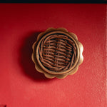 Delilah Round Knob Teak, Aged Brass close up on red