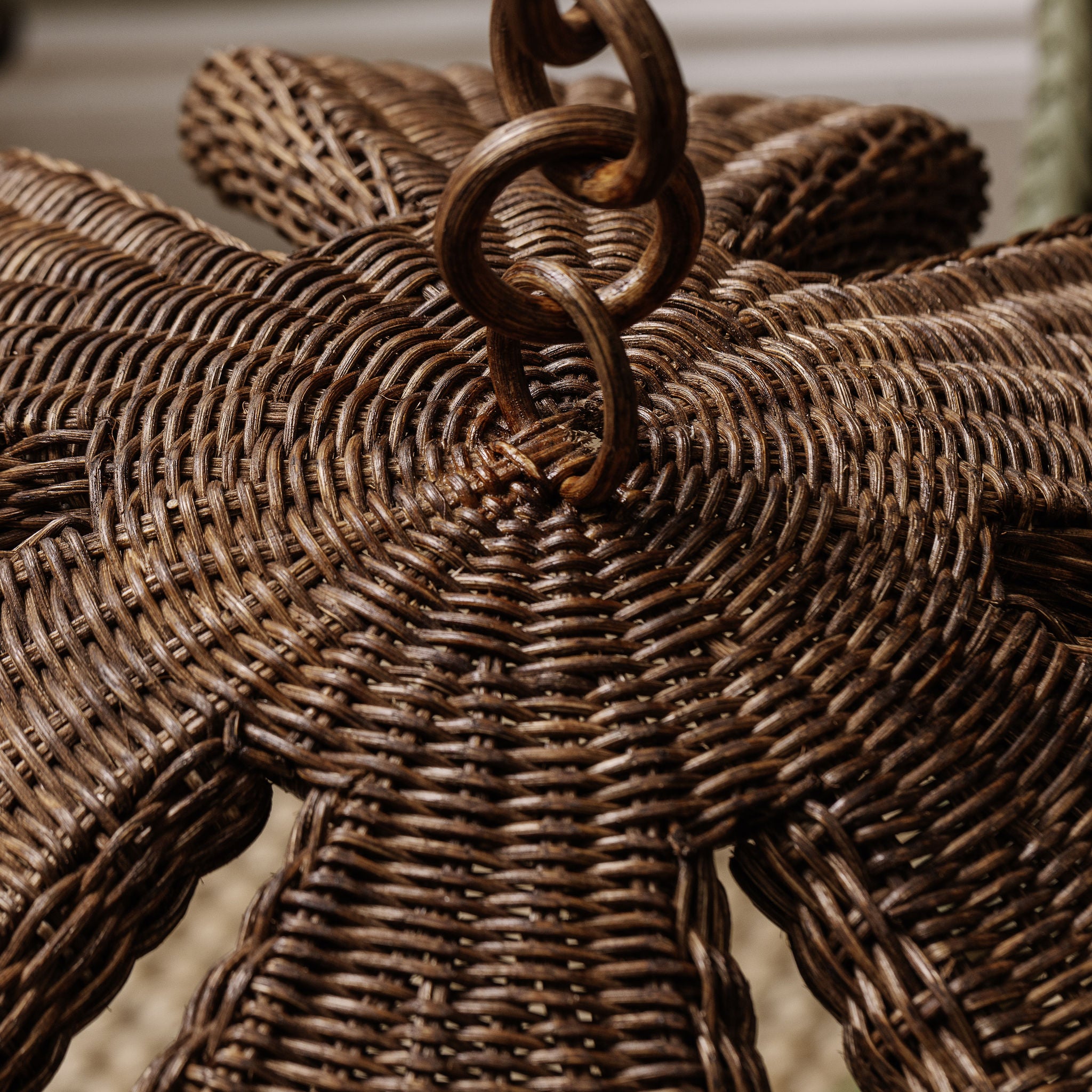 Close-up of a woven wicker pendant with a decorative handle.