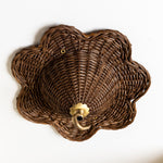 Wicker wall basket with a decorative metal fixture on a white background