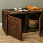 Wicker storage bench with open magazine and folded clothes on a neutral background