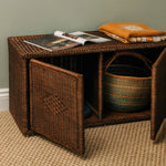 Wicker storage bench with open magazine and folded clothes on a neutral background