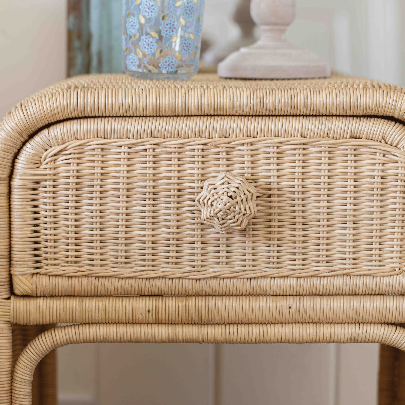 Wicker side table with decorative items on top