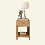 Phoenix Wicker side table with lamp, flowers, and books on a white background