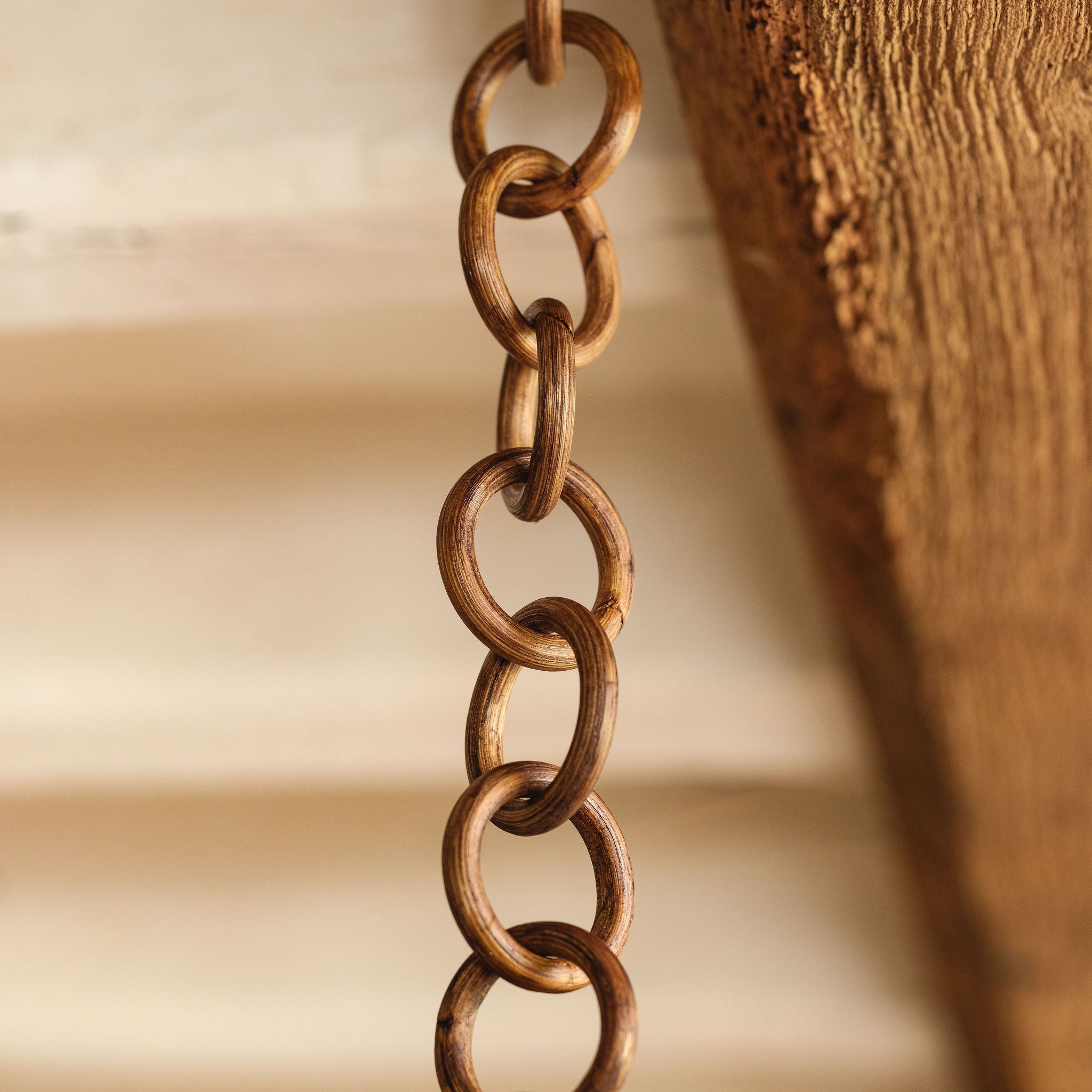A teak brown round rattan link chain with an antique brass link.
