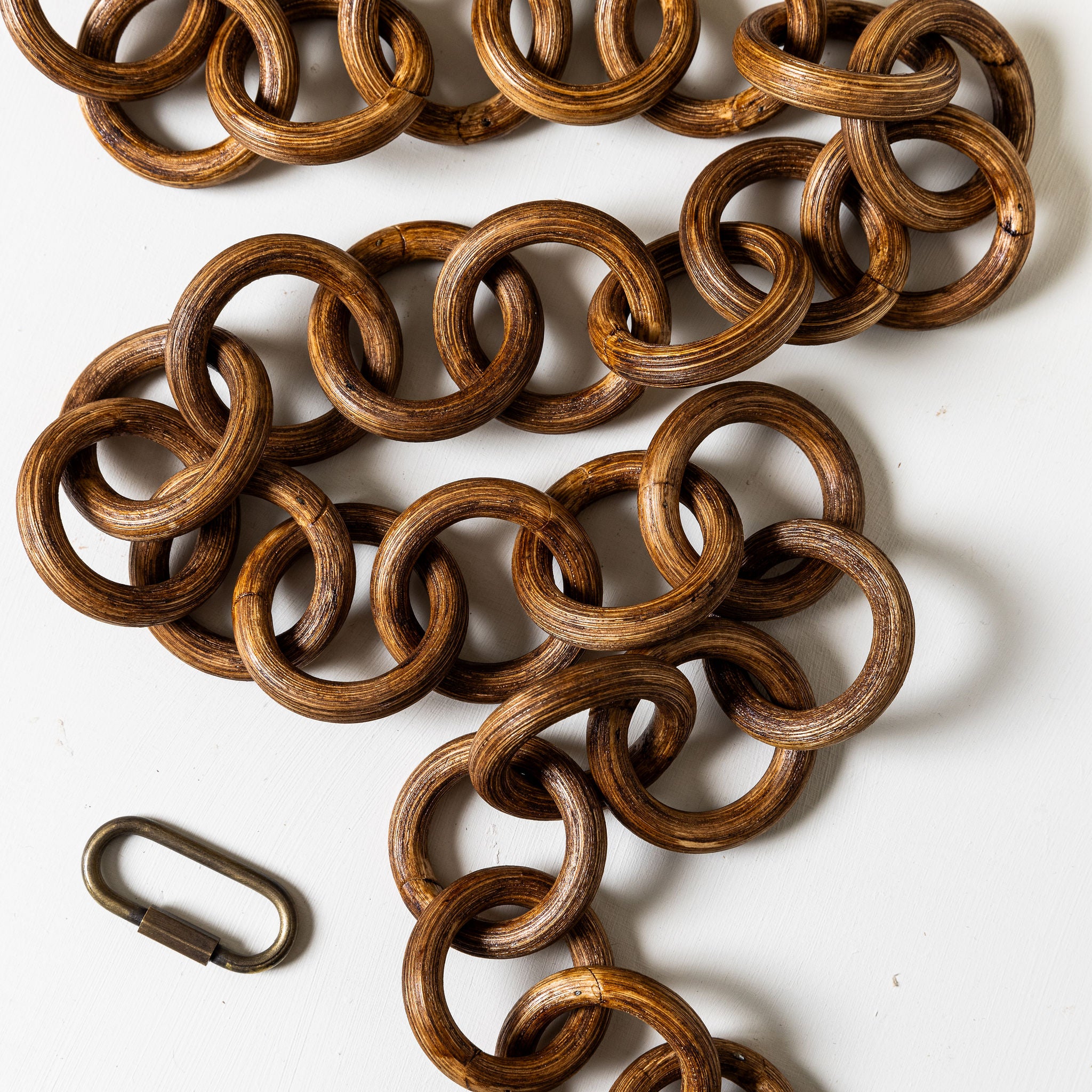 Brown metal chain with a carabiner on a white background