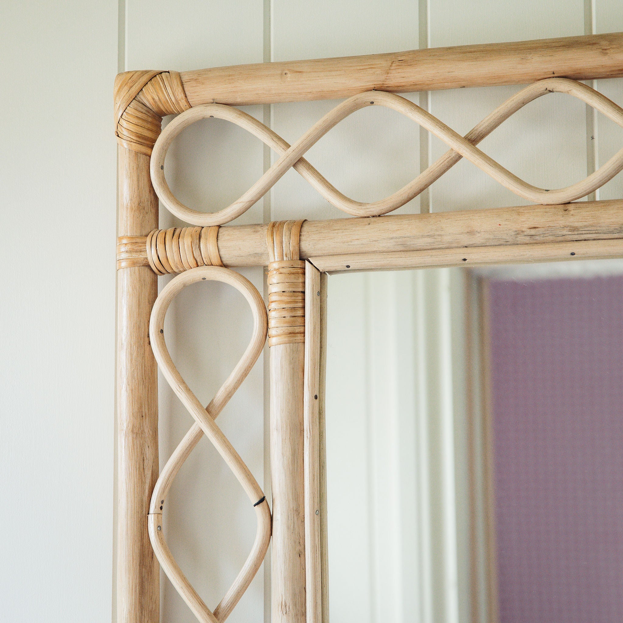 Retro-rattan-mirror-on-a-white-wall-close-up-top