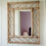 Retro-rattan-mirror-on-a-white-wall-close-up