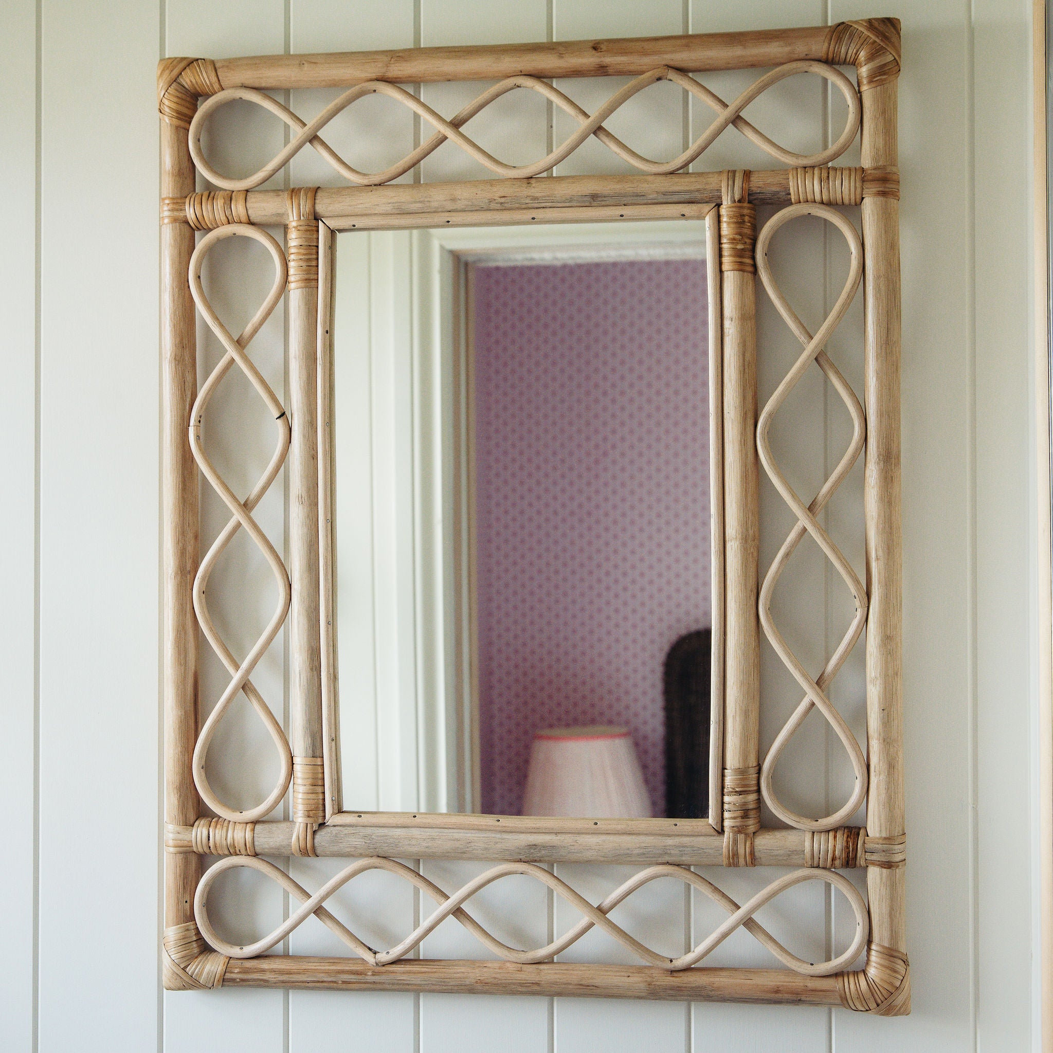 Retro-rattan-mirror-on-a-white-wall-close-up