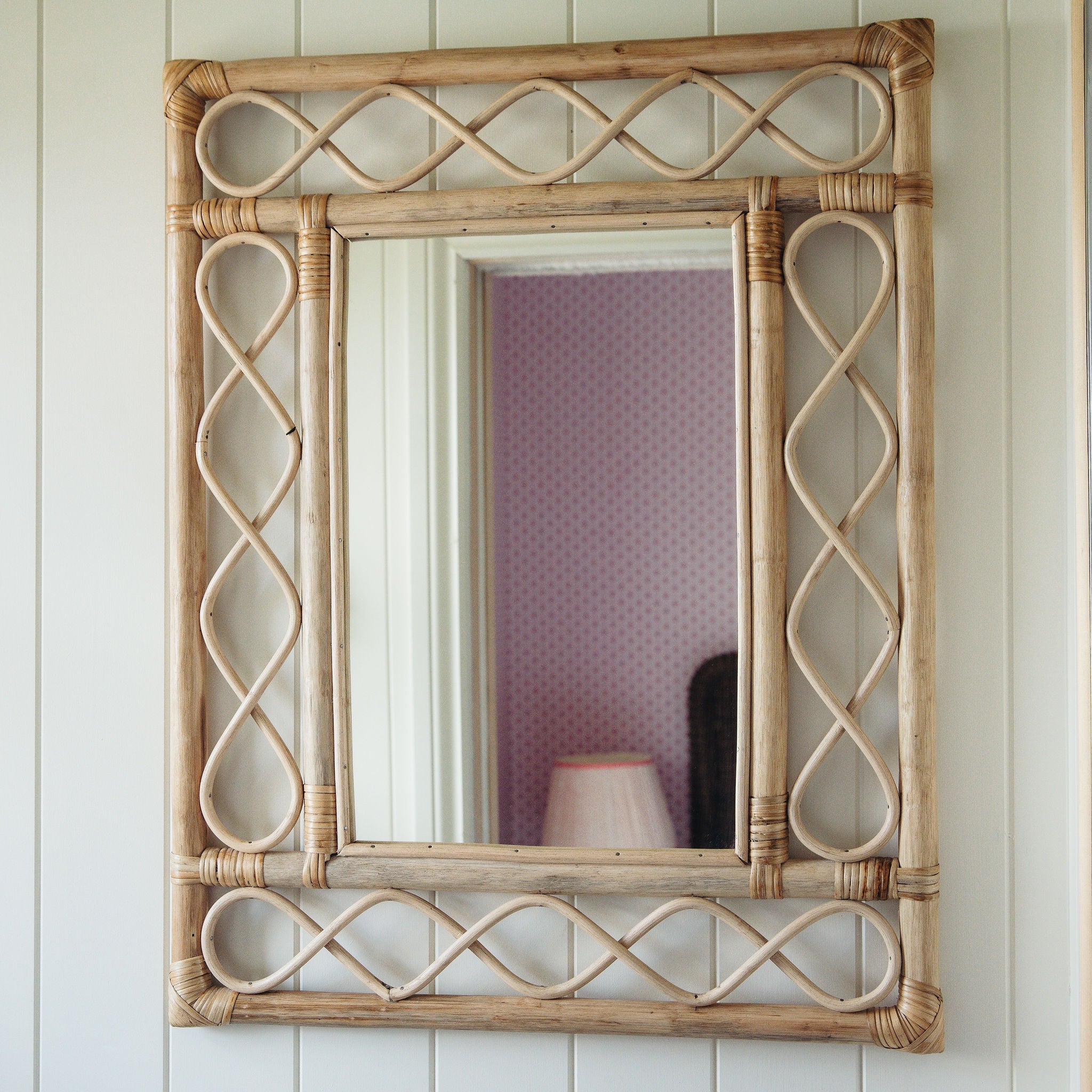 Retro-rattan-mirror-on-a-white-wall-close-up