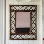 Retro-rattan-mirror-teak-on-a-white-wall-close-up