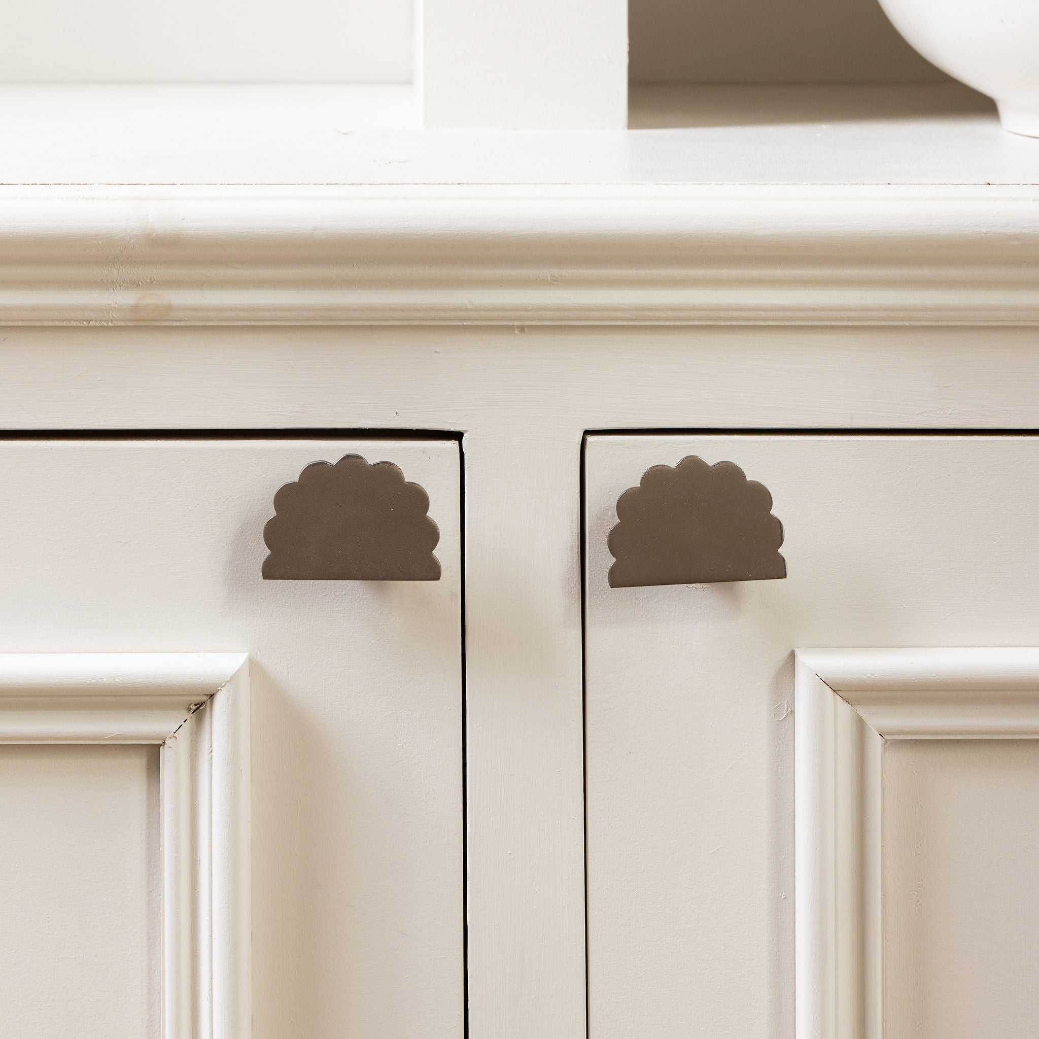 Scallop-knob-polished-brass-on-a-cabinet