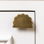 Brass cloud-shaped handle on a white cabinet