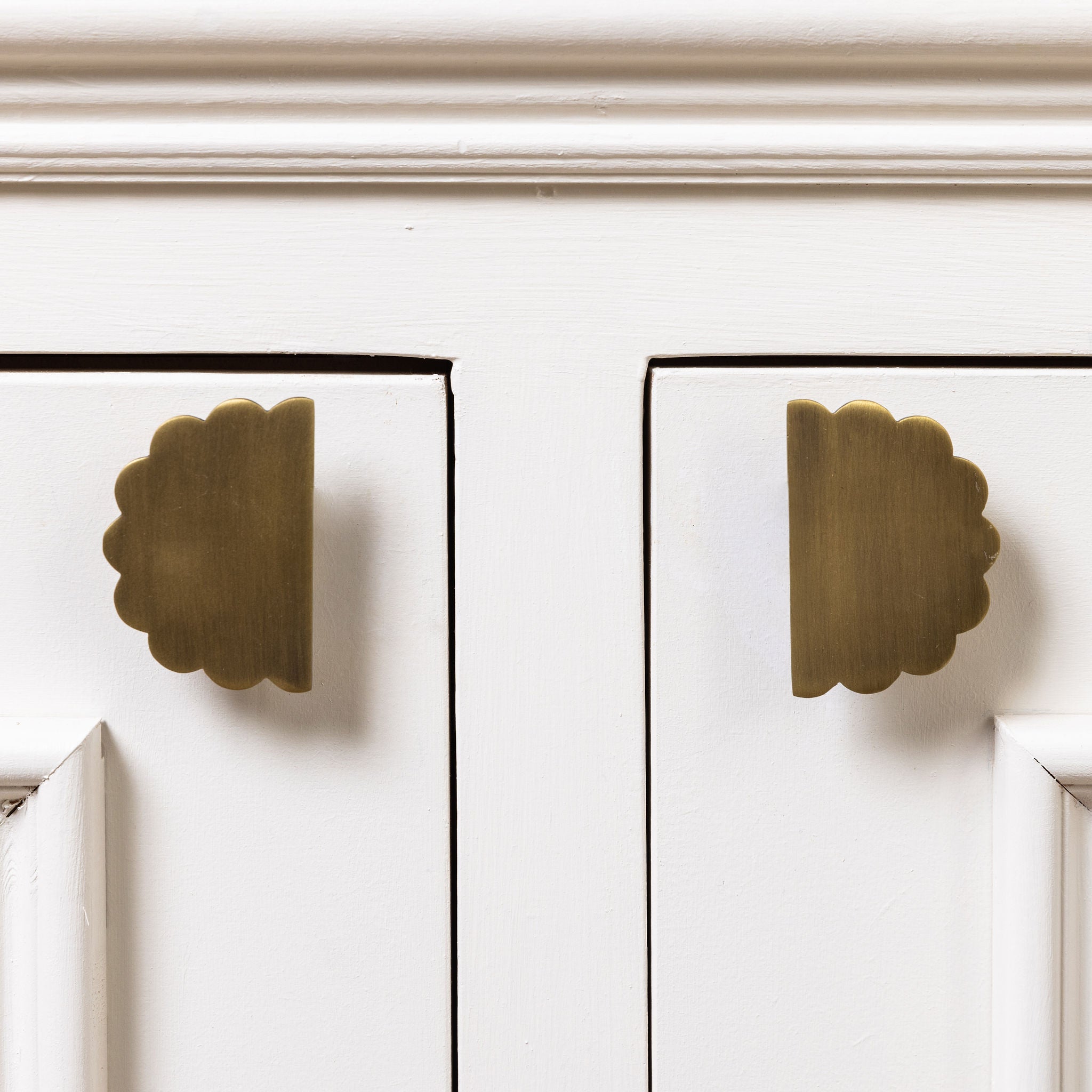 Scallop-knobs-antique-brass-on-a-cabinet