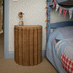 Shell Rattan Side Table, Oak by bed