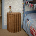 Shell Rattan Side Table, Oak by bed
