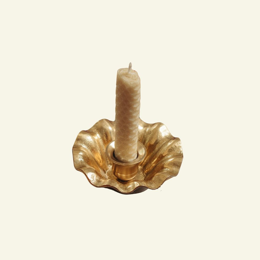 Wave candle holder with a white candle on a beige background